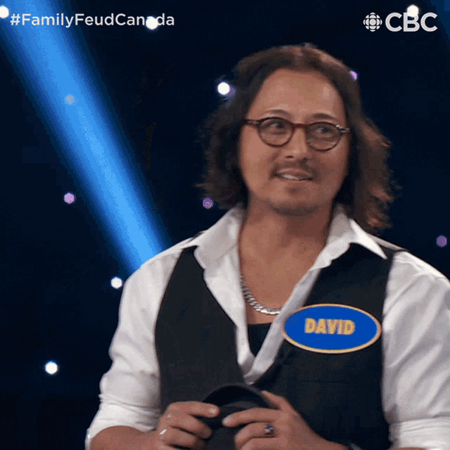 a man wearing glasses and a vest with the name david on it