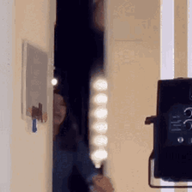 a person is standing in front of a mirror holding a light bulb .