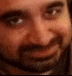 a man with a beard is smiling and looking at the camera .