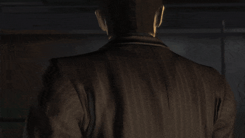 a man with a tattoo on his back holds a black object