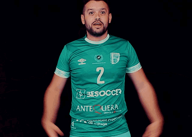 a man is wearing a green jersey with the number 2 on it