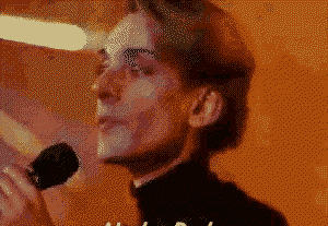 a pixelated image of a man singing into a microphone with the letter a visible