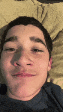 a young man laying on a bed with his eyes closed and his mouth open