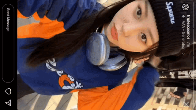 a woman wearing headphones and a supreme hat