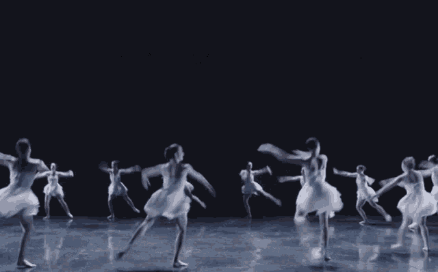 a group of ballet dancers are dancing in a circle