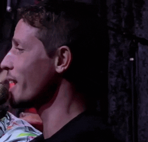 a man singing into a microphone with a yellow stripe on it
