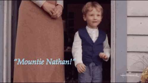 a little boy standing in front of a door with the words " mountie nathan " written above him