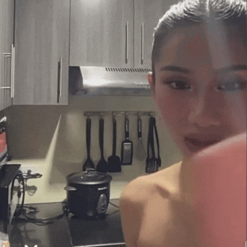 a woman is standing in a kitchen with a philips rice cooker