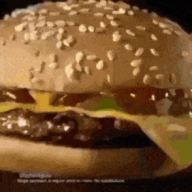 a close up of a hamburger with sesame seeds on top of it