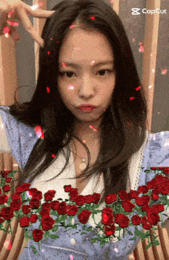 a girl with long hair is surrounded by red roses and petals with the caption capcut