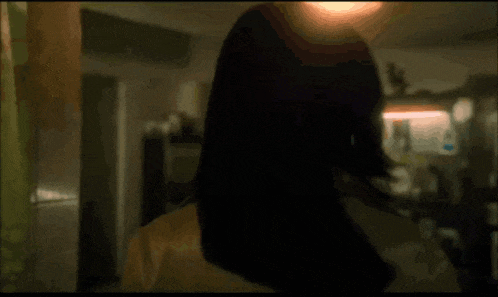 a woman wearing sunglasses and a wig stands in a dark room
