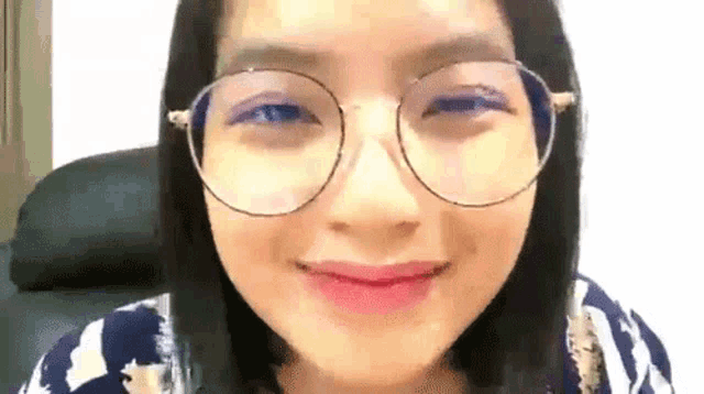 a woman wearing glasses is smiling for the camera .