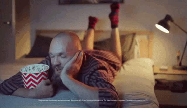 a man laying on a bed eating popcorn with the words sequence simulated and shortened at the bottom