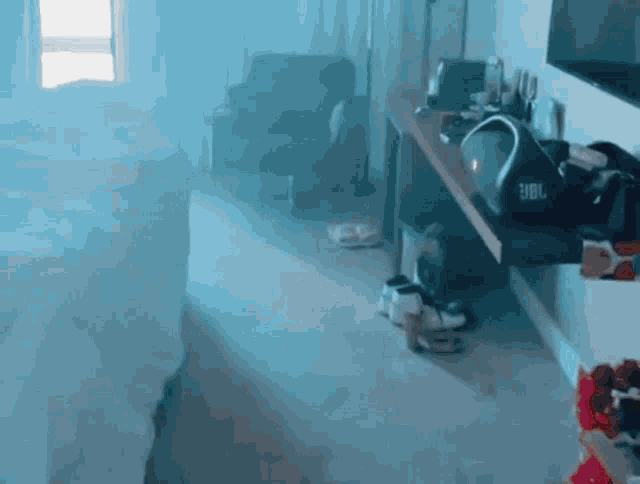 a blurry picture of a room with a jbl speaker on a desk