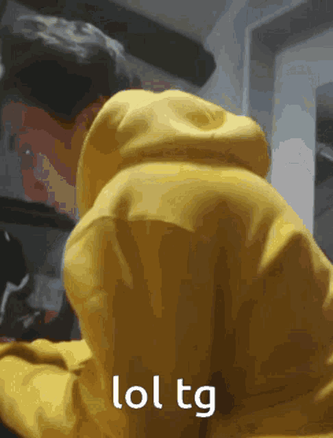a person wearing a yellow hoodie says lol tg on the bottom