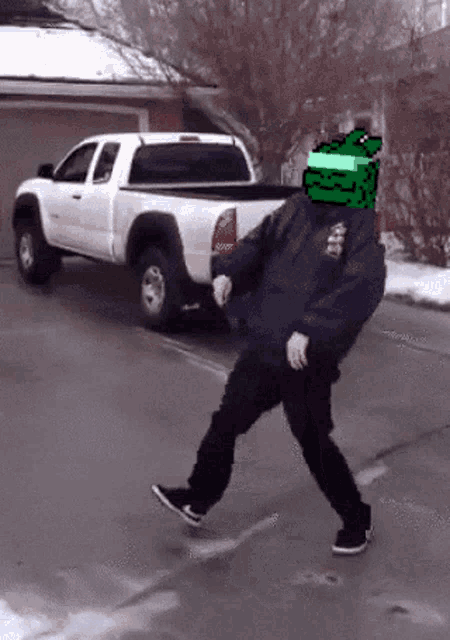 a man with a green head is walking down the street in front of a truck