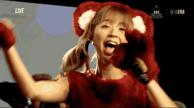a woman in a teddy bear costume with the words live on the bottom