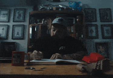 a man sitting at a desk wearing a black ftp shirt