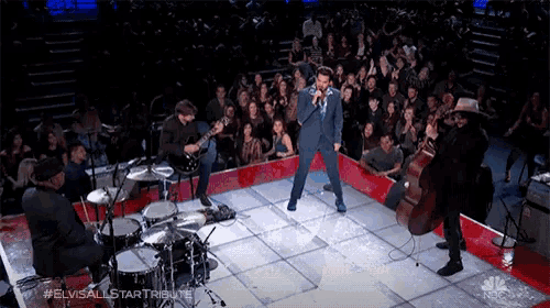 elvis all star tribute performing on stage with a crowd watching