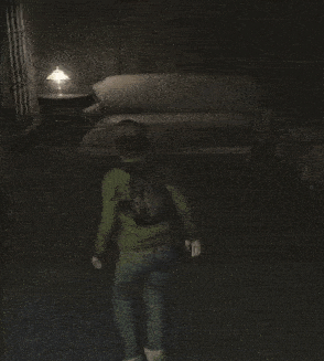a person standing in a dark room with a couch