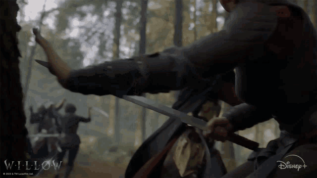 a disney + advertisement for willow showing a man holding a sword