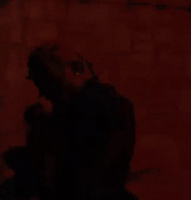 a man with horns on his head is dancing in front of a brick wall