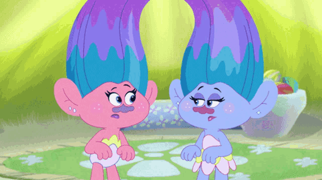 a couple of trolls standing next to each other with purple hair