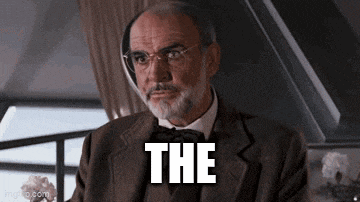 a man with a beard and glasses is wearing a suit and bow tie and says the .