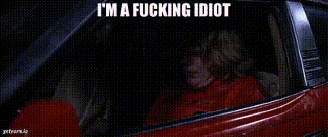a woman is sitting in a car with the words i 'm a fucking idiot written above her