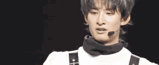 a close up of a person 's face with a microphone in front of him .