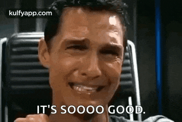 a man is smiling and crying while sitting in a chair with his eyes closed .