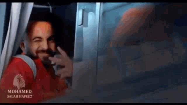 a man in a red shirt with the name mohamed on it