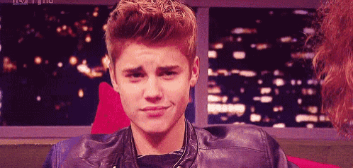 a young man wearing a leather jacket is making a funny face .