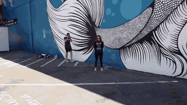 two people are standing in front of a mural that says splash history