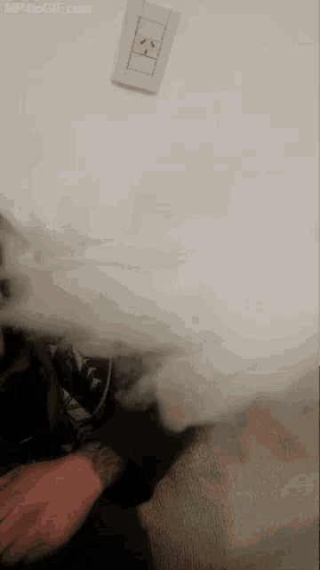 a person is blowing smoke from their mouth and the website mp4togif.com is on the bottom right
