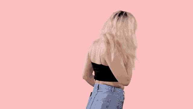 a woman in a black top and blue jeans is dancing .
