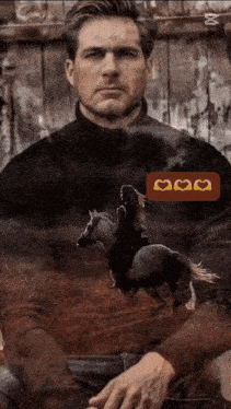 a man is sitting in front of a fence with a woman riding a horse .