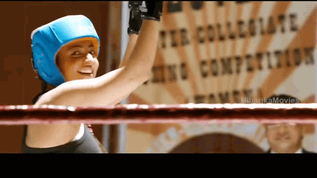 a woman in a boxing ring with a sign in the background that says the collegiate boxing competition