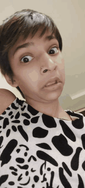 a woman making a funny face wearing a black and white shirt