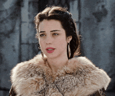 a woman is wearing a fur coat with a collar