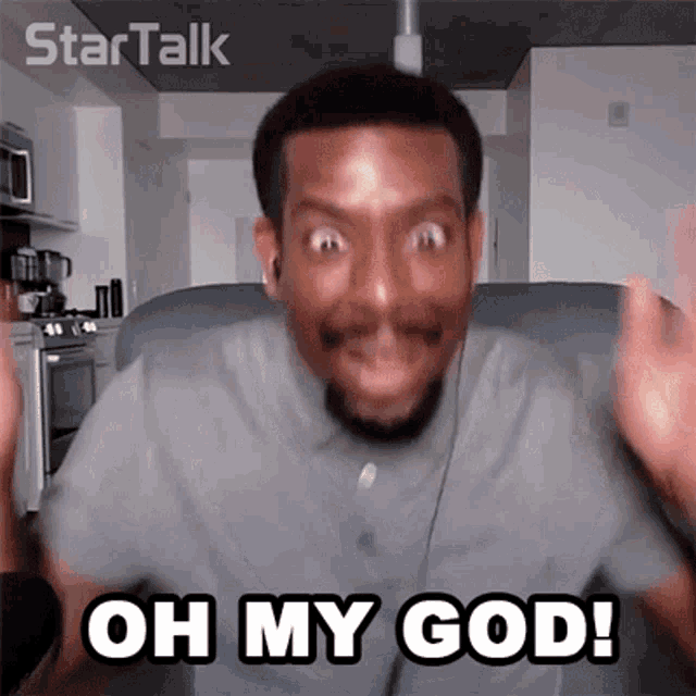 a man is sitting on a couch with his hands in the air and says oh my god