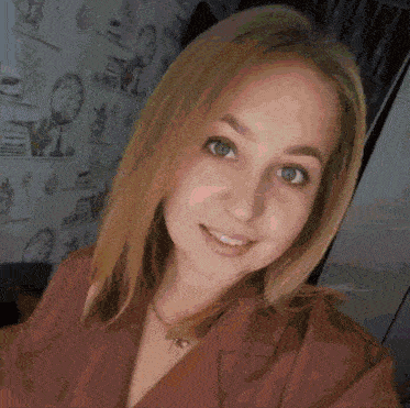 a woman is smiling in front of a wall with clocks
