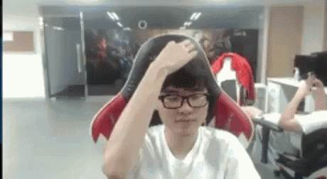 a man wearing glasses and a white shirt is sitting in a gaming chair .