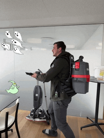 a man with a vacuum cleaner on his back is standing in front of ghosts