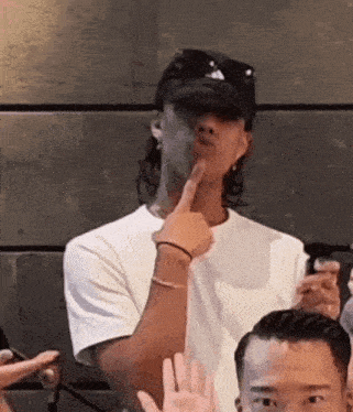 a man wearing a hat and sunglasses is giving a high five to a group of people .