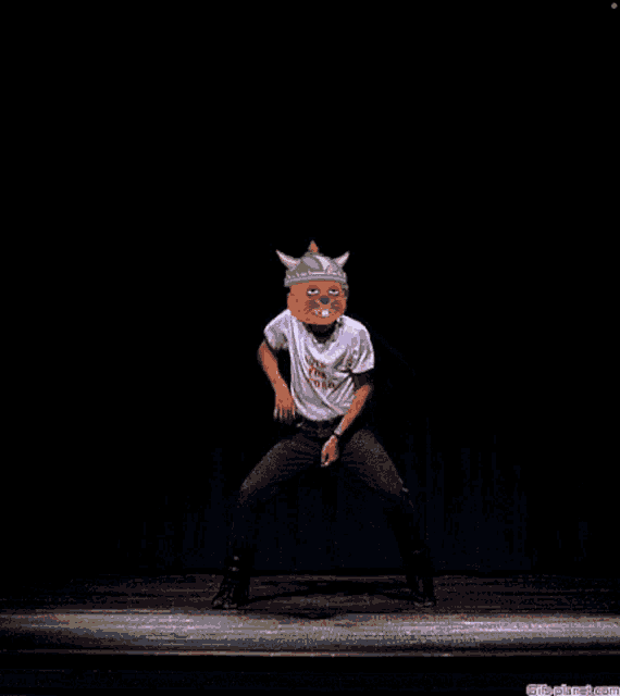 a man wearing a shirt that says ' it 's a pig ' on it stands on a stage