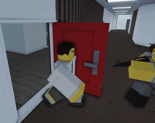 a man in a white shirt is standing in a hallway with a red door