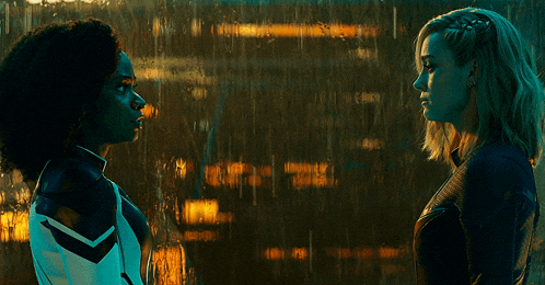 two women standing next to each other in front of a window with rain drops on it