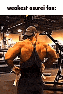 a man is flexing his muscles in a gym while wearing a hat and headphones .