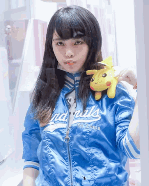 a girl in a blue jacket that says cardinals on it
